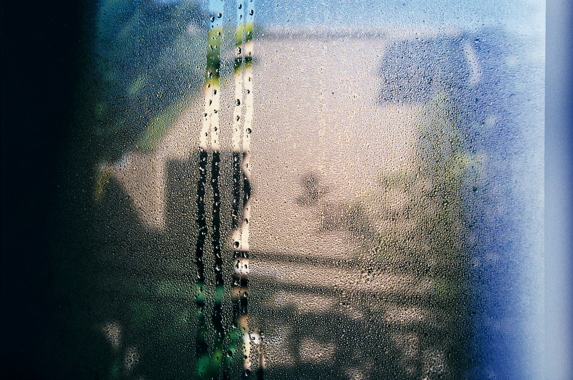 Water droplets formed by condensation on a glass window surface
