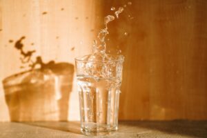 Clear glass of water sitting on a table in natural light