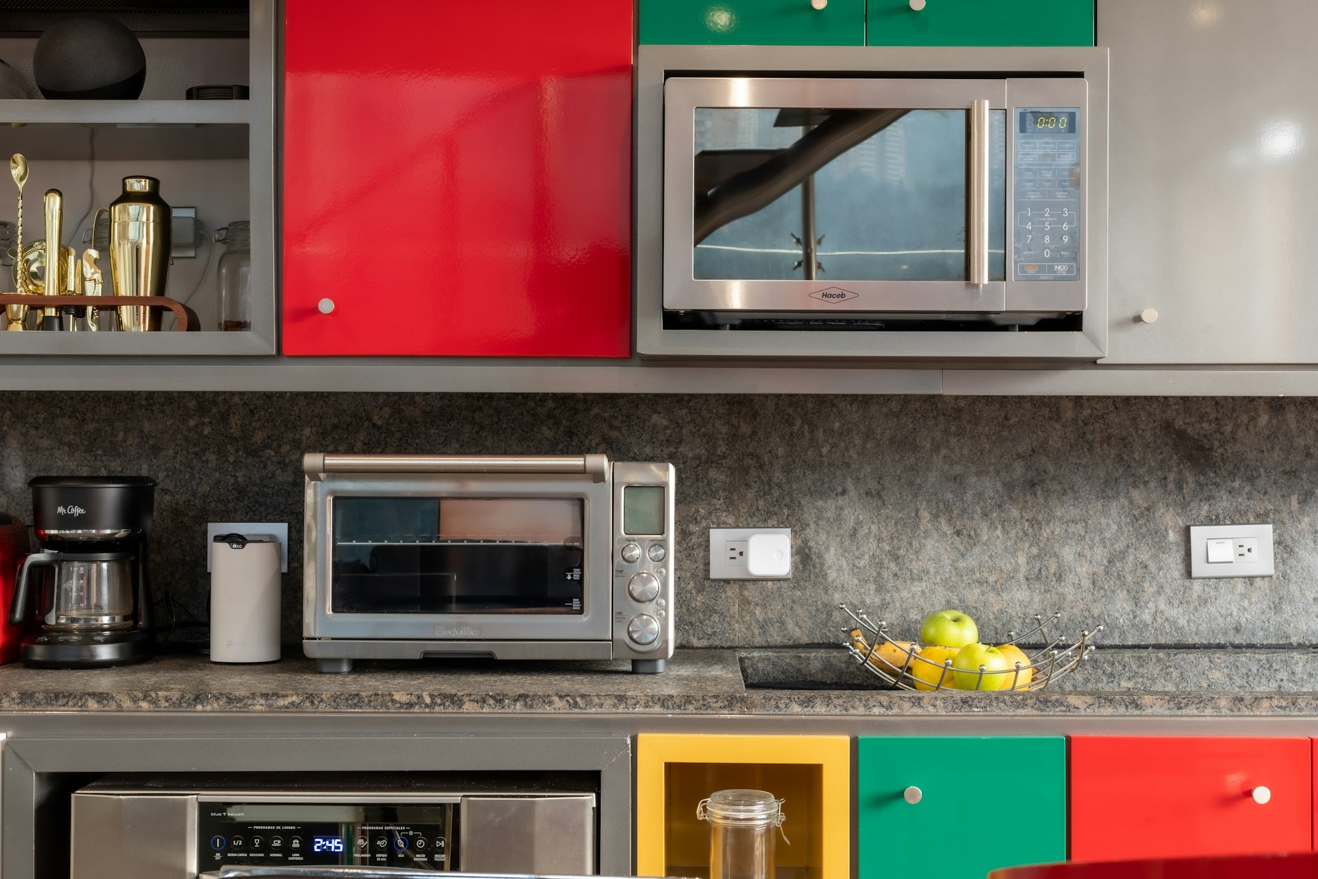 Microwave, countertop convection oven, and built-in dishwasher in a modern kitchen
