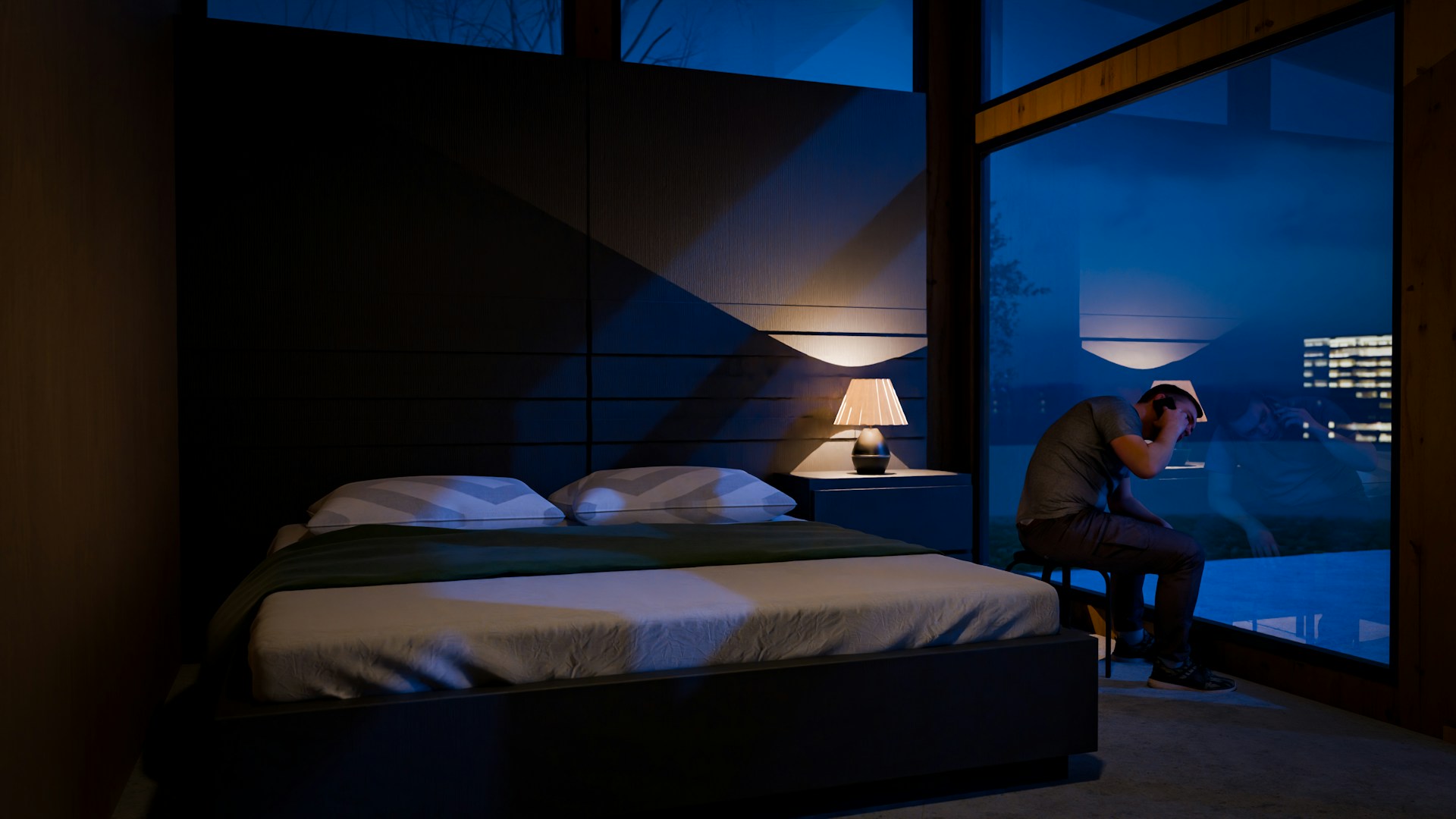 Person sitting on a bed in a dark bedroom using a smartphone at night