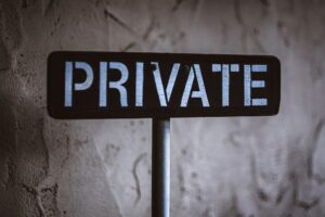 Black and white wooden sign with directional arrows pointing in different directions