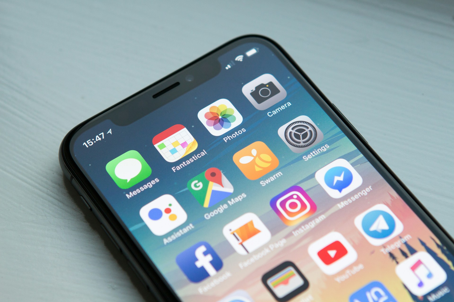 Space gray smartphone displaying multiple app icons on the home screen