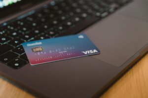 Blue credit card resting on a laptop keyboard representing online subscription billing
