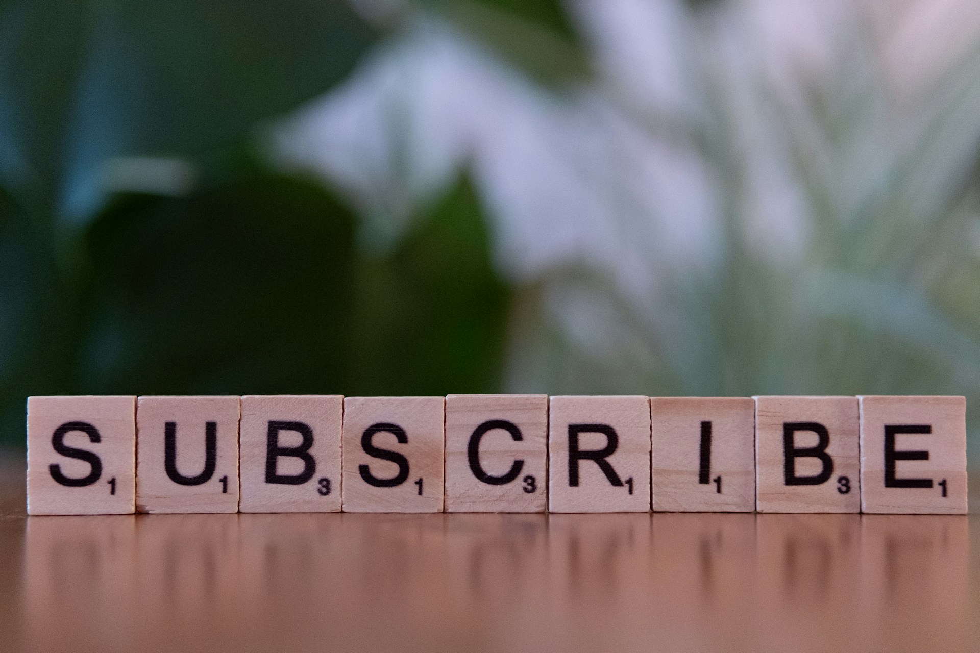Wooden blocks spelling “subscribe” on a table