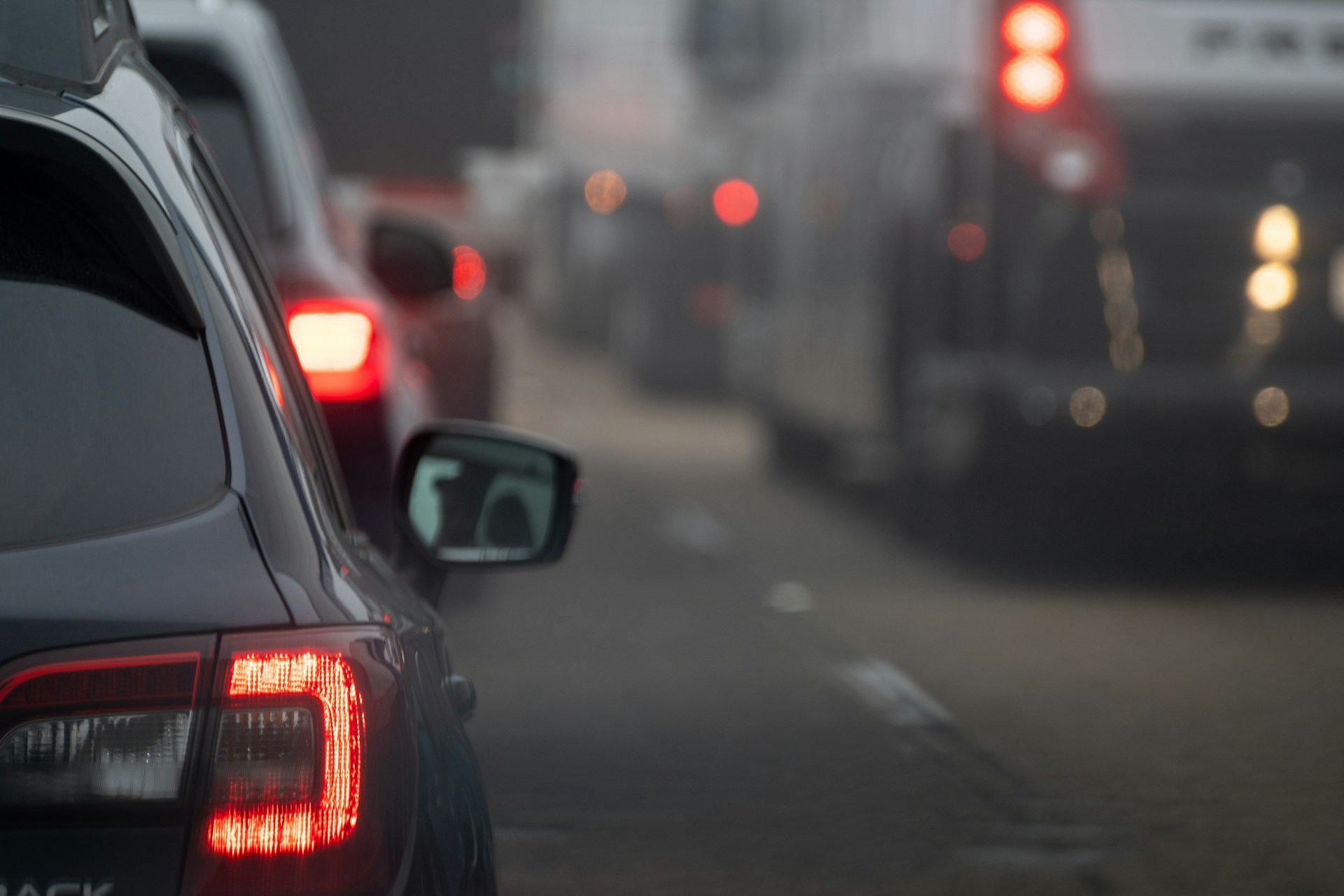 Multiple cars traveling closely together on a busy roadway