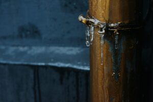 Icicles hanging from an outdoor metal pipe in freezing temperatures