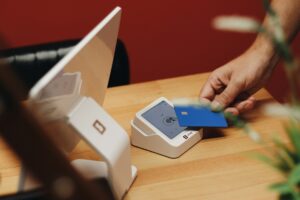 Person tapping a credit card on a payment terminal for a contactless transaction