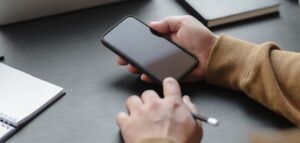 Person looking at a smartphone screen in a dim office setting while checking device storage or phone status