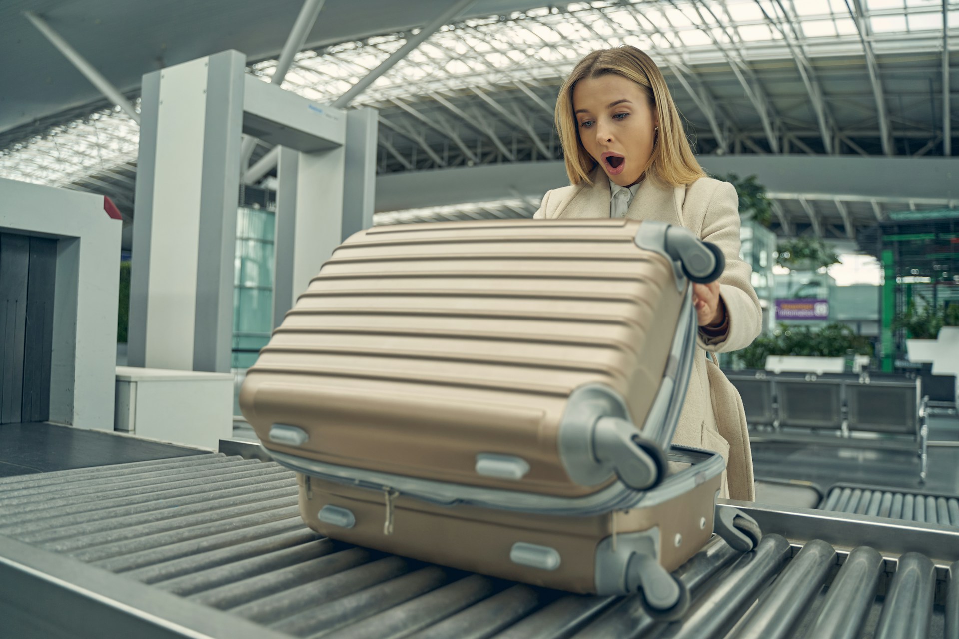 Woman checking suitcase after travel and noticing contents inside luggage