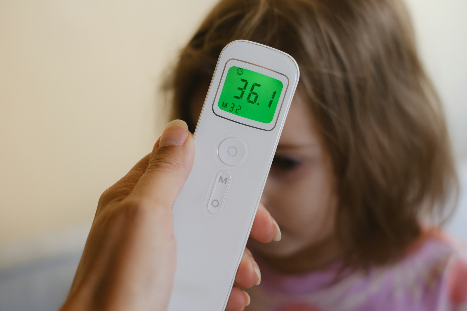 Person using a digital thermometer to check body temperature