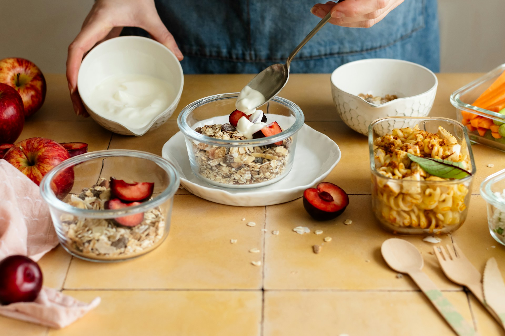 Person preparing a bowl of cereal and fruit, representing nutrients the body uses for energy and normal bodily functions
