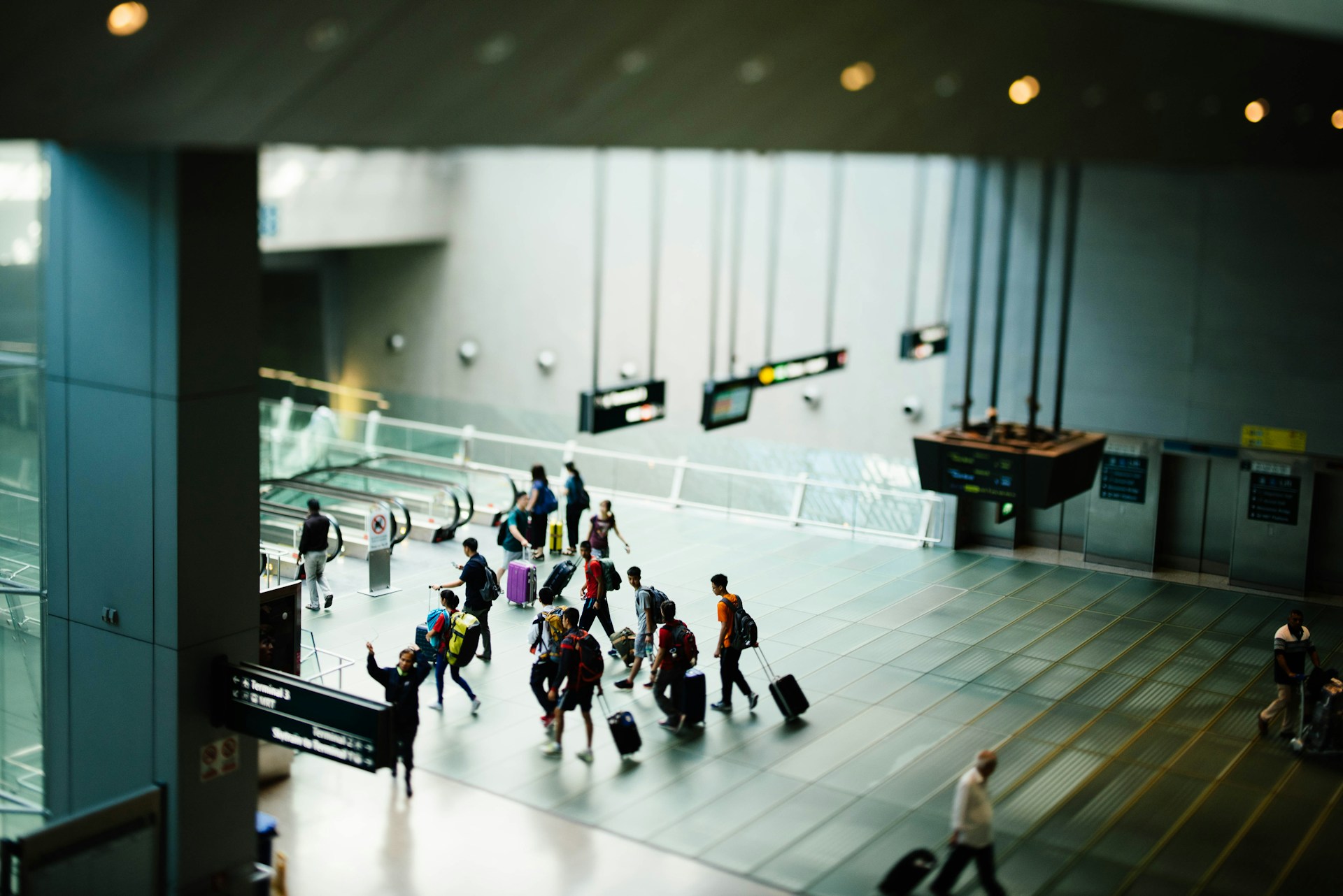 Travelers walking through an airport terminal during the international arrivals process.