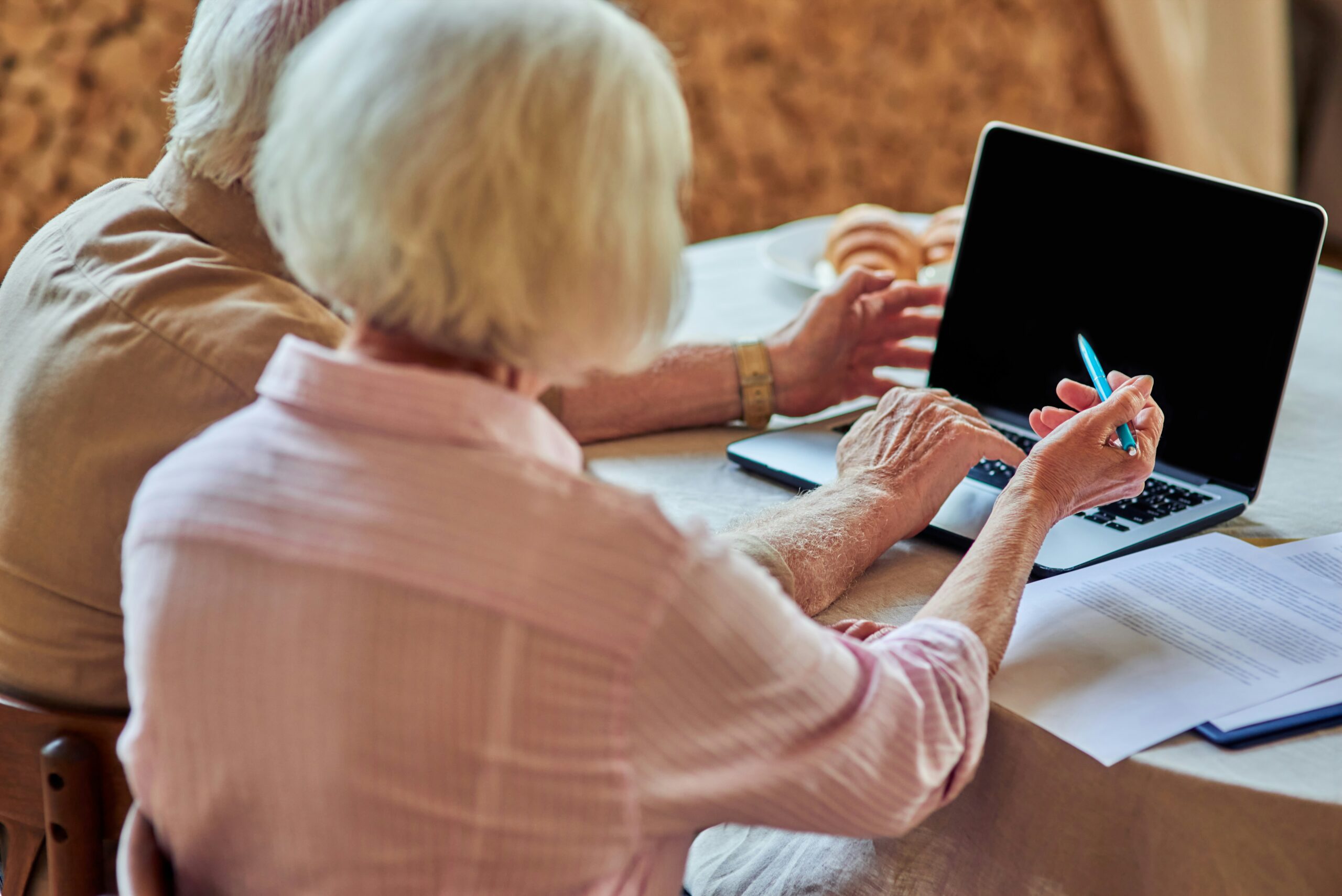 Older couple reviewing retirement account information together on a laptop at home