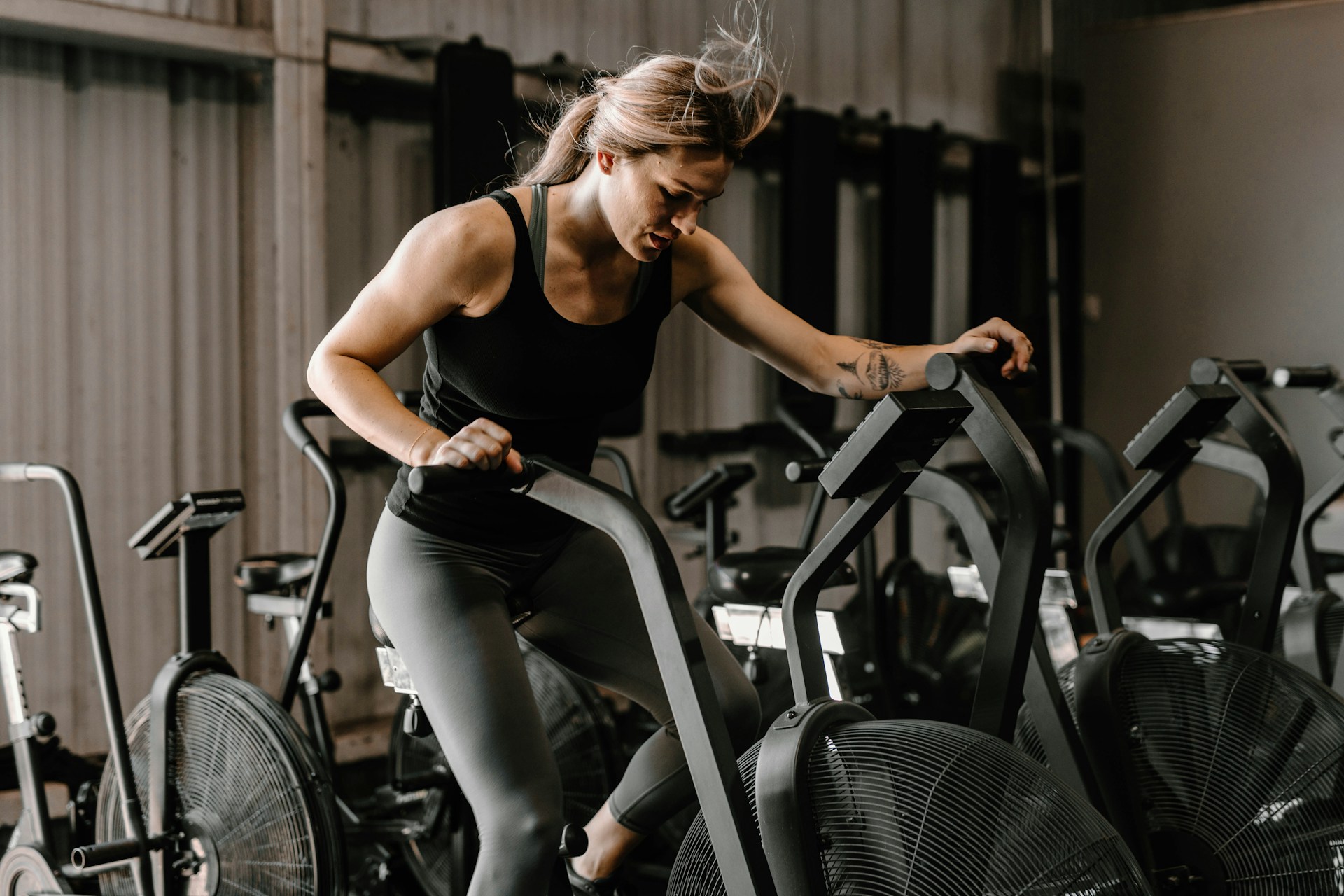 Woman riding a stationary bike during a workout as her breathing naturally increases with exercise.