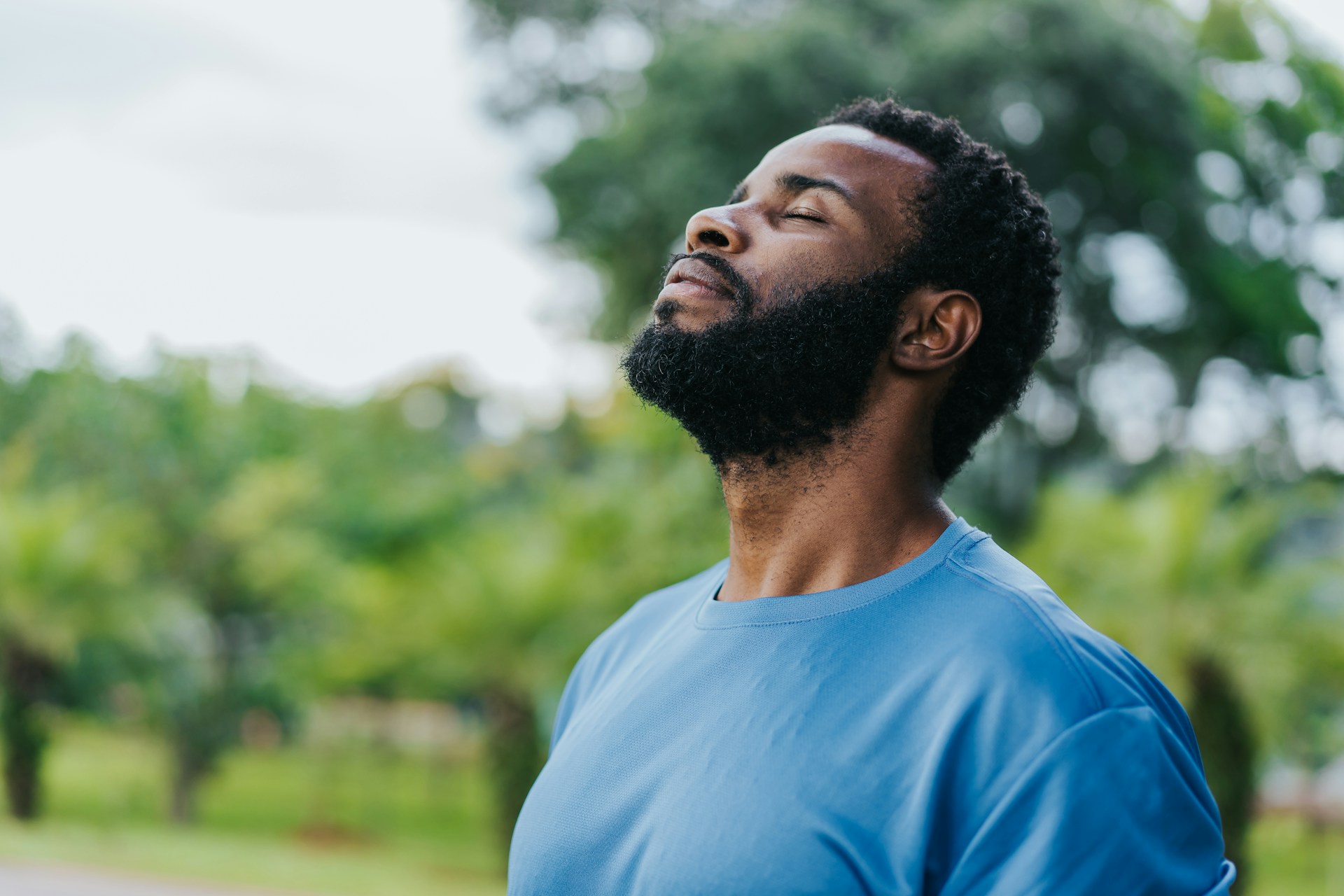 Person breathing through their nose outdoors with a relaxed expression.