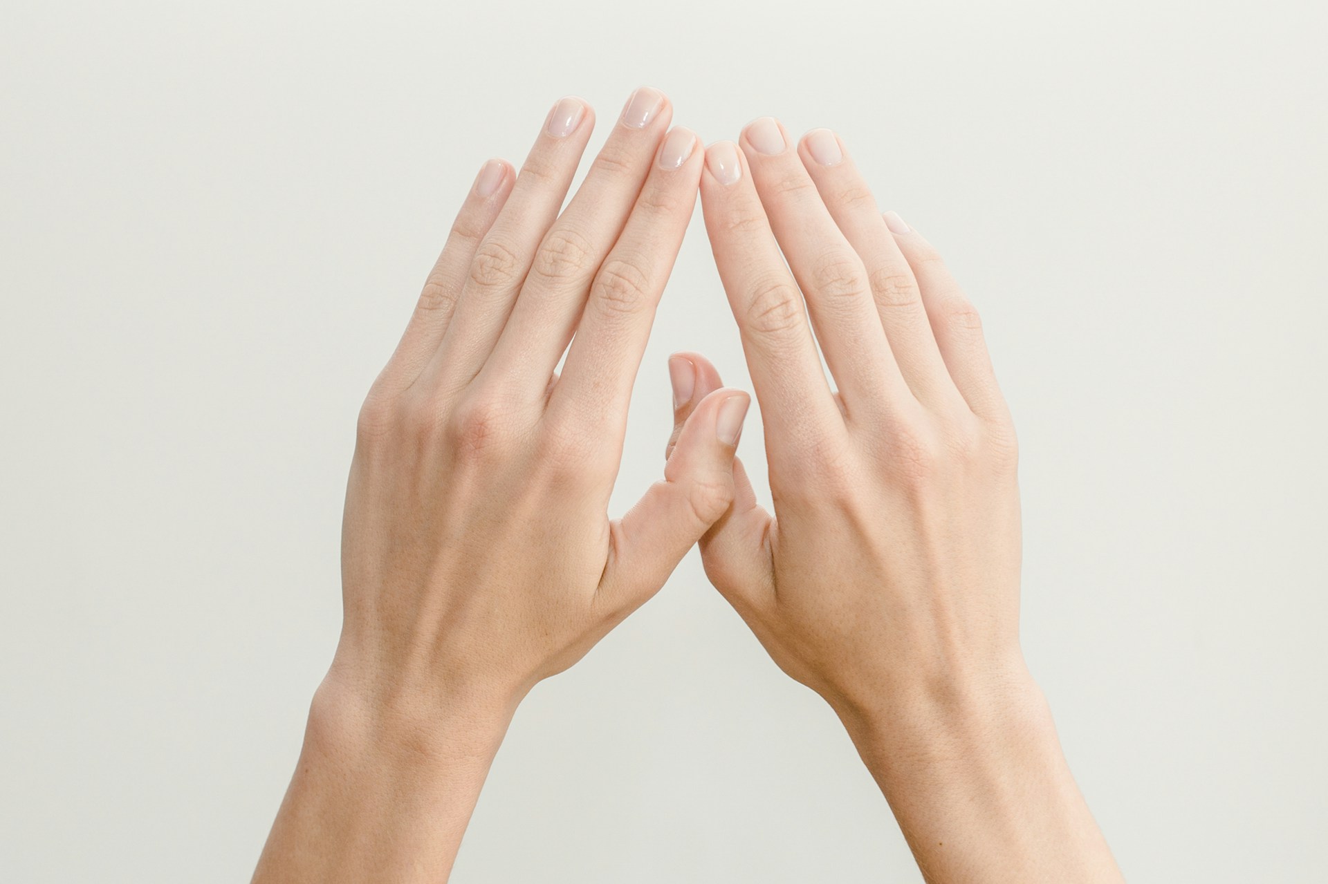 Close-up of a person's hands with natural fingernails, illustrating the topic of brittle nails.
