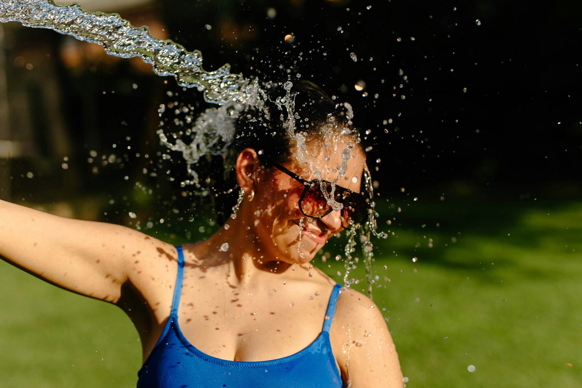 Person pouring water over their face to cool down after feeling warm.