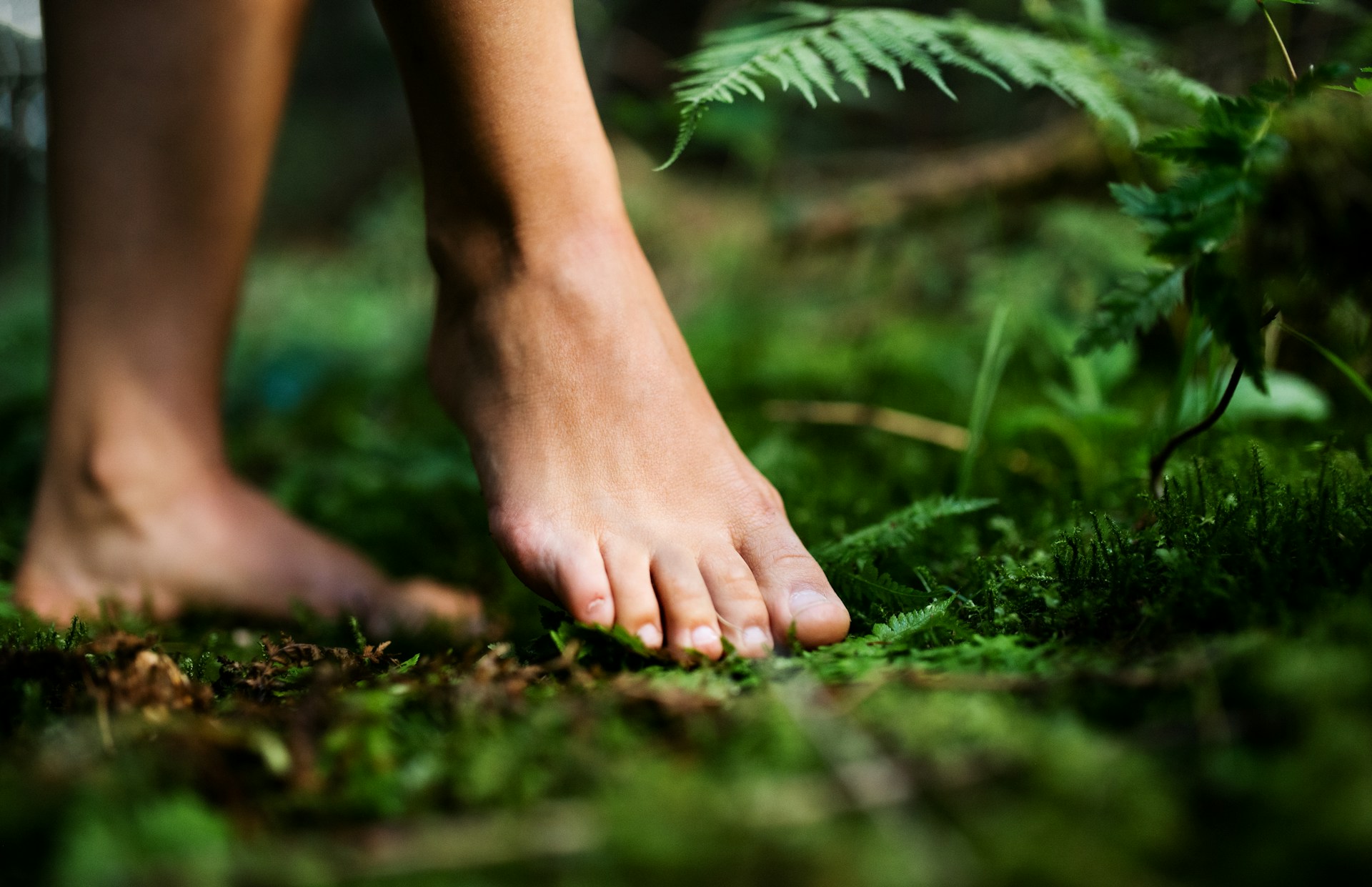 Bare feet standing on the ground outdoors.