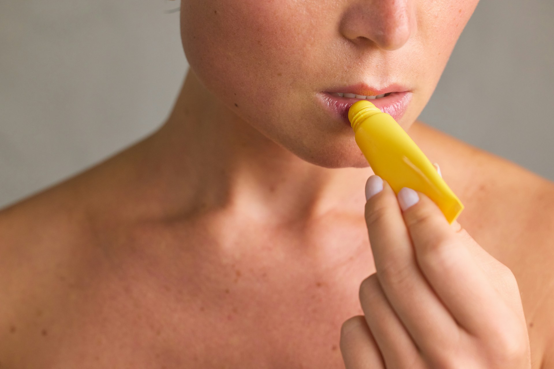 Person applying lip balm to dry lips.