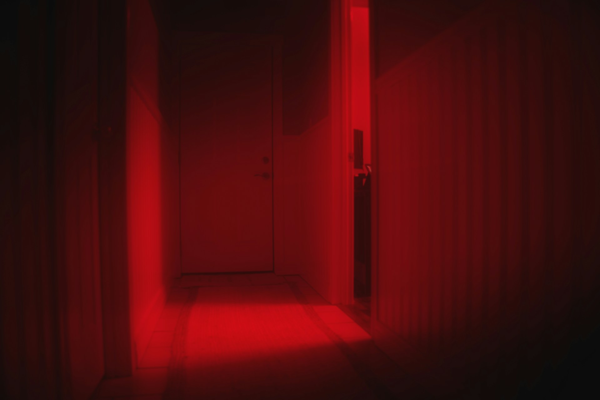 Dark bedroom with an open doorway, illustrating the unsettling atmosphere often associated with nightmares during sleep.