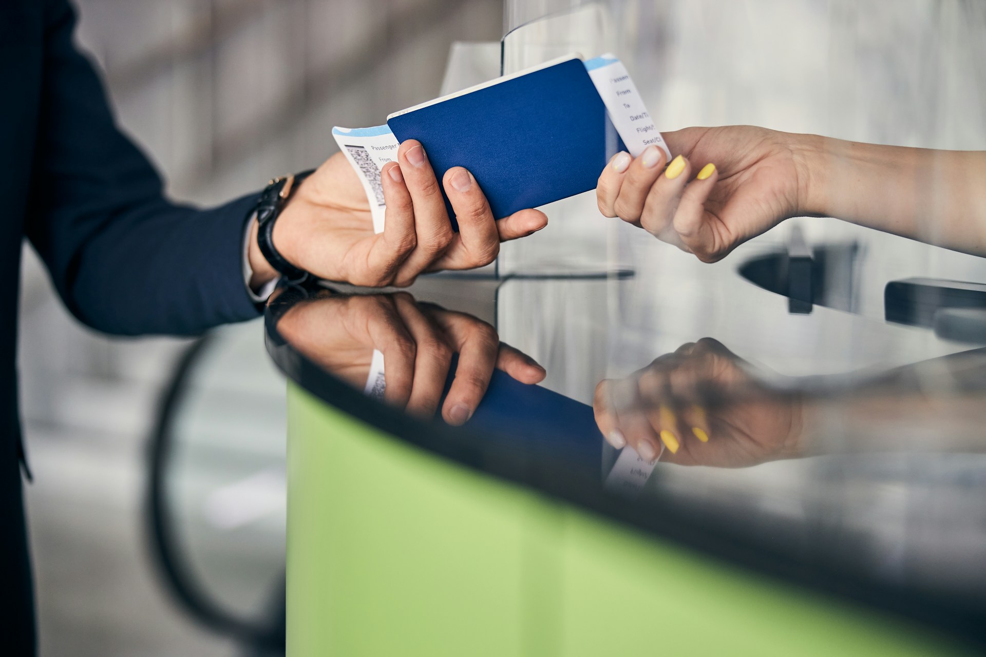 Traveler presenting a passport and travel documents at a passport control checkpoint.