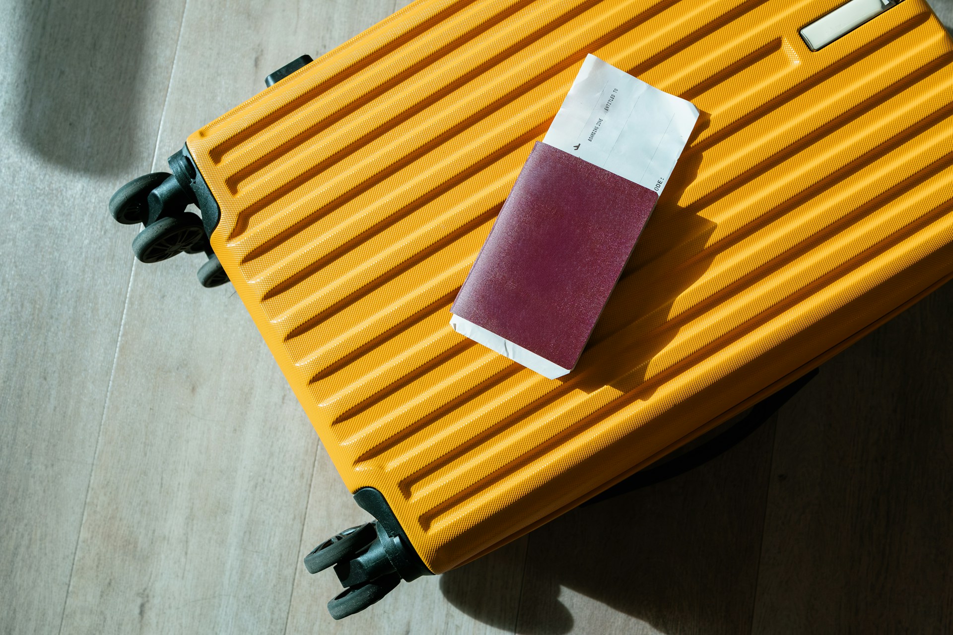 Yellow suitcase with a passport resting on top before international border inspection