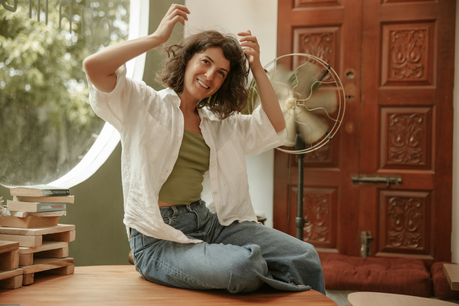 Person sitting in front of a fan after cooling down following physical activity or warm weather.