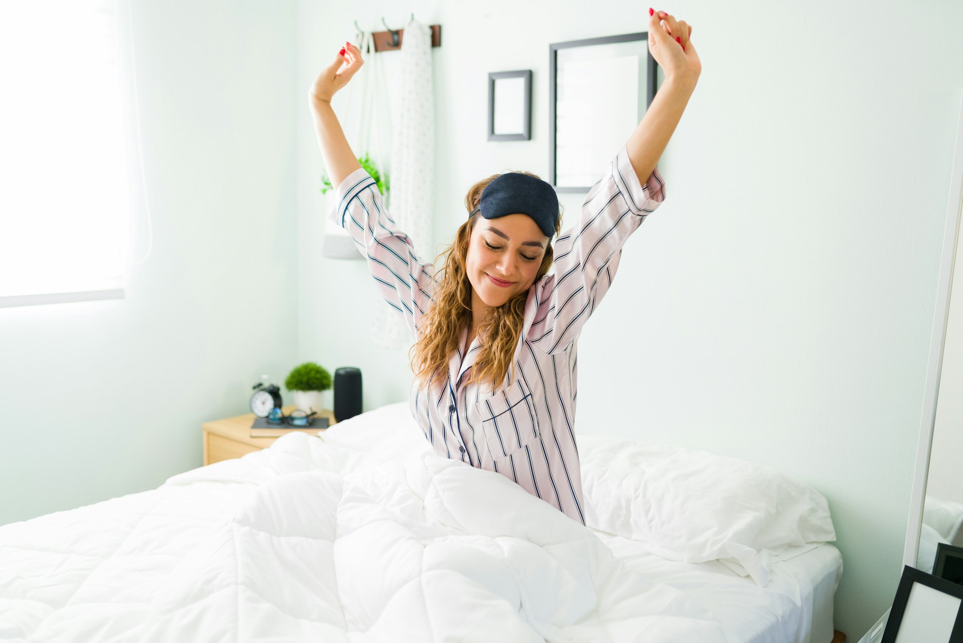 Person stretching in bed after waking up in the morning.
