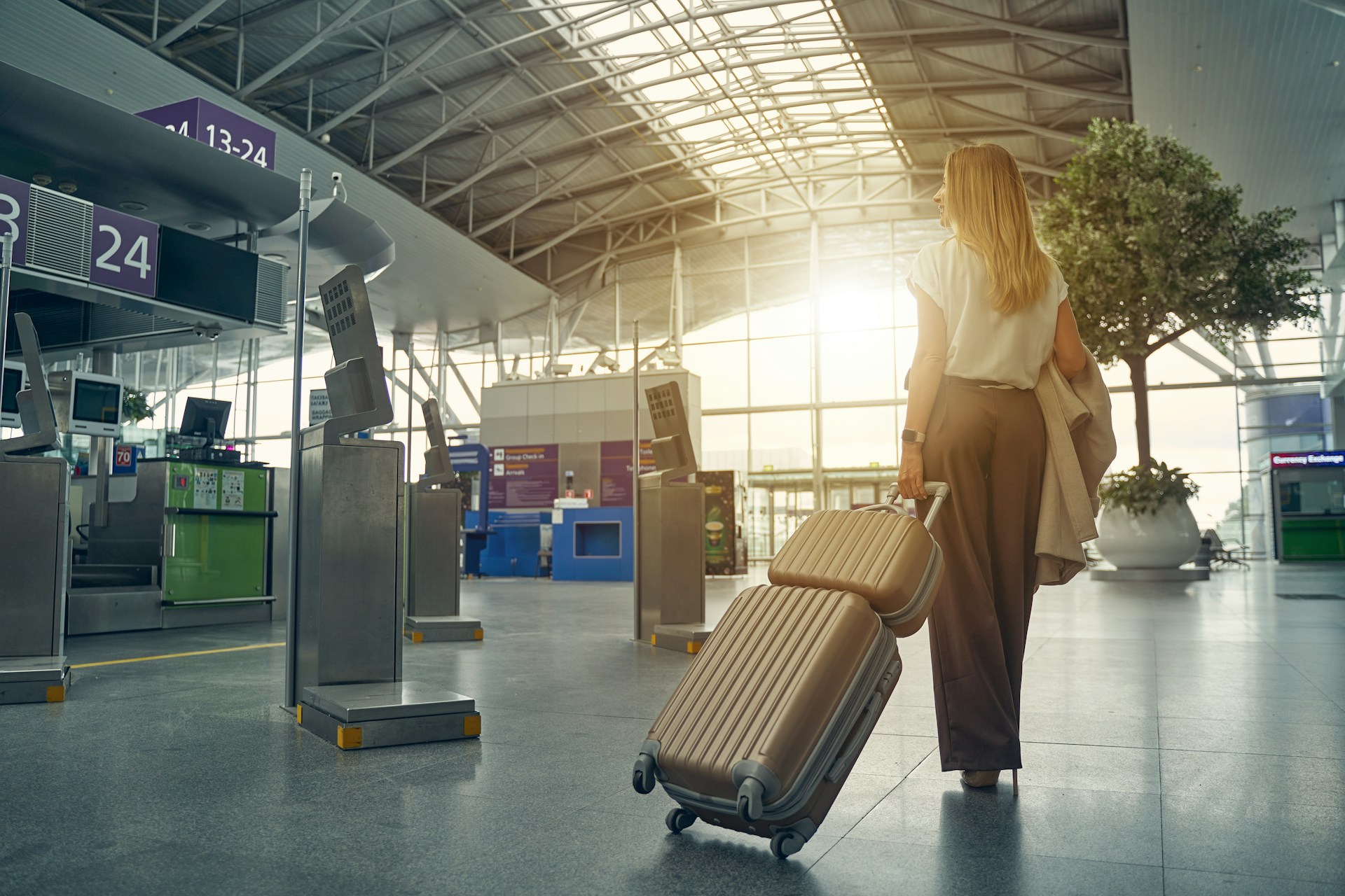 Traveler walking through an airport terminal with luggage while heading to a connecting flight.