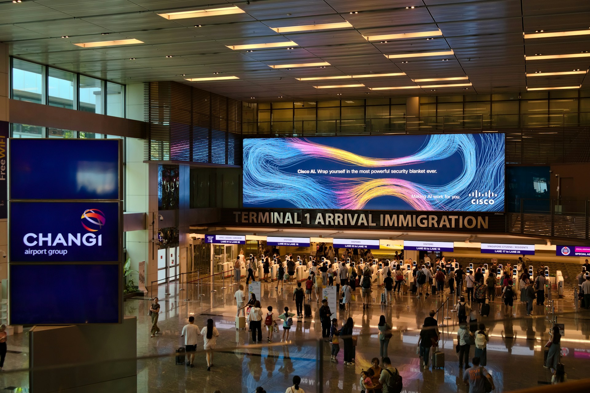 Travelers walking through an international airport arrivals area toward immigration.