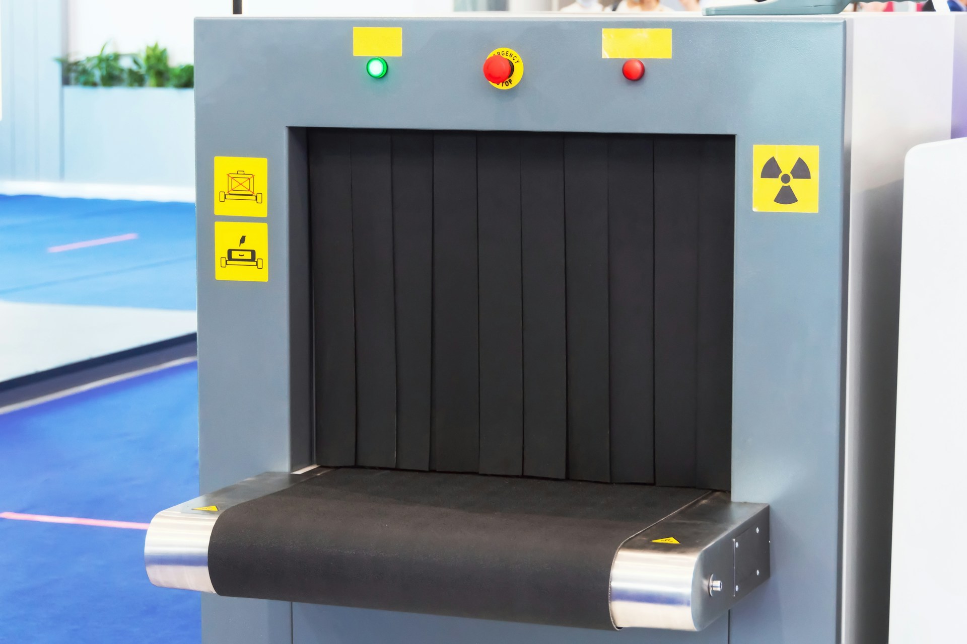 Airport baggage screening equipment examining luggage during a customs inspection process.