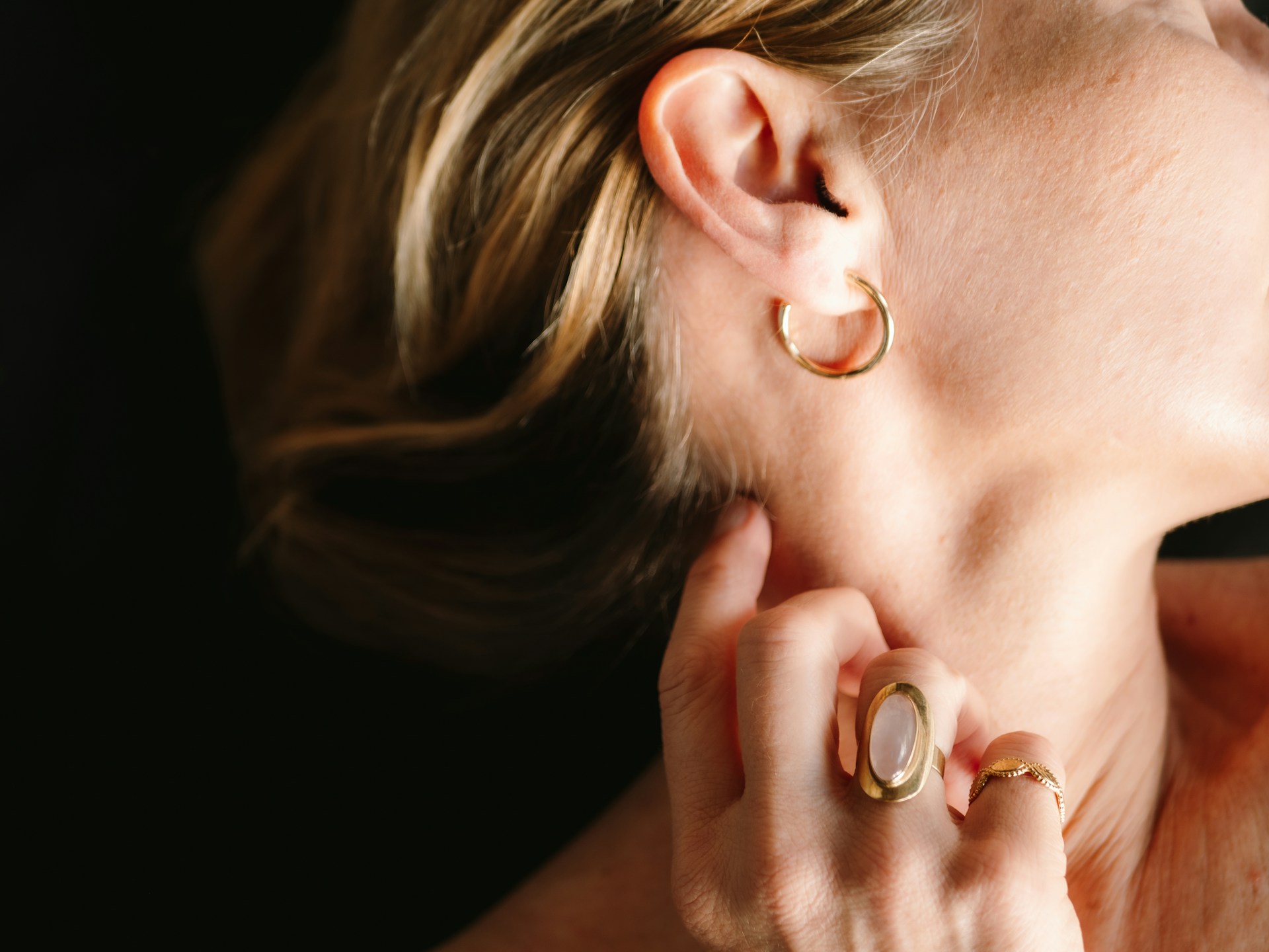 Person gently touching their ear.