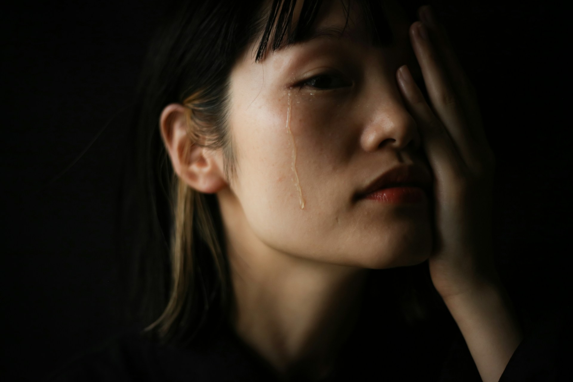 Close-up of a woman with tears on her face during an emotional moment.