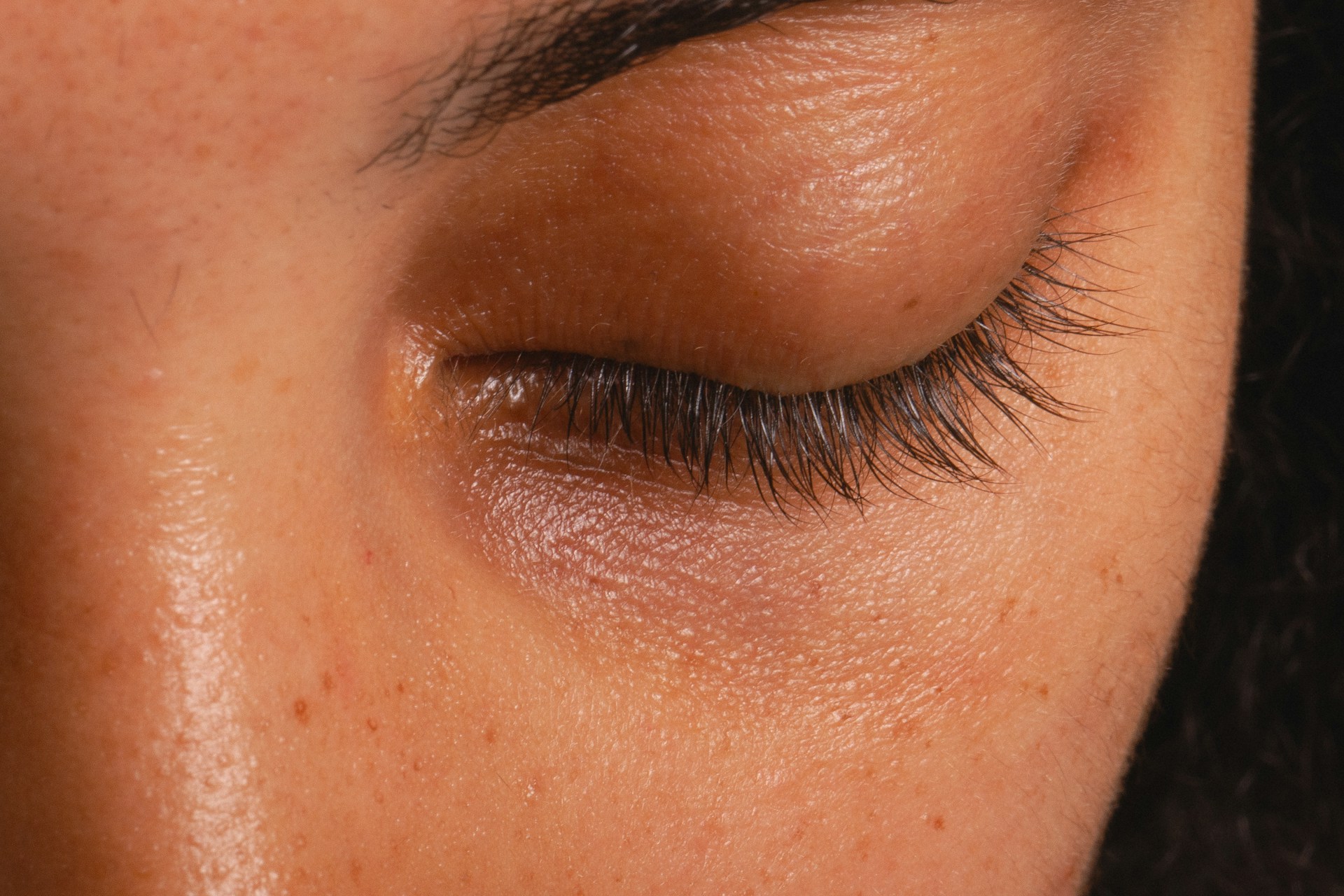 Close-up of a closed human eye showing the eyelid and eyelashes during a blink.