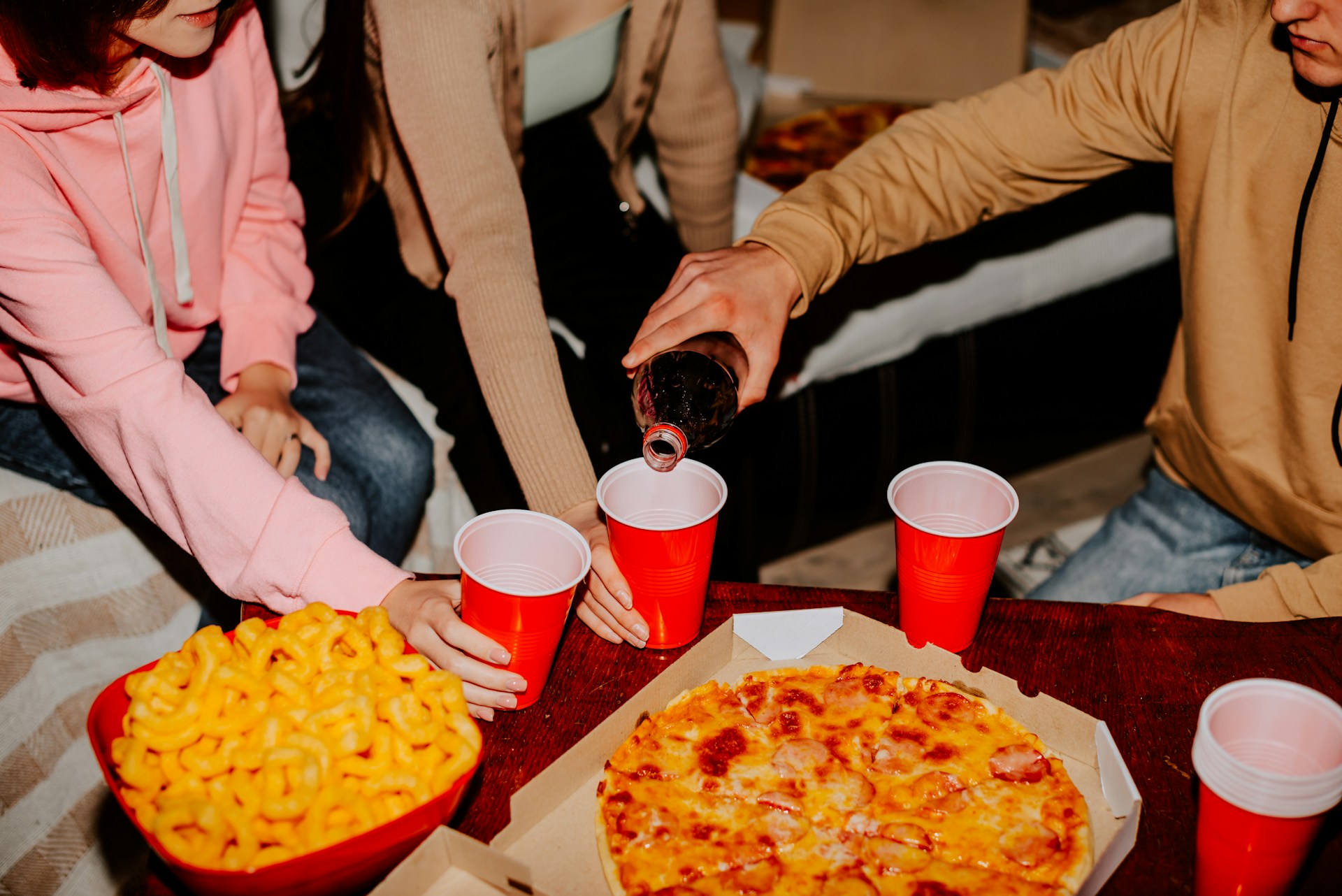 People sharing a meal with food and drinks at a dining table.