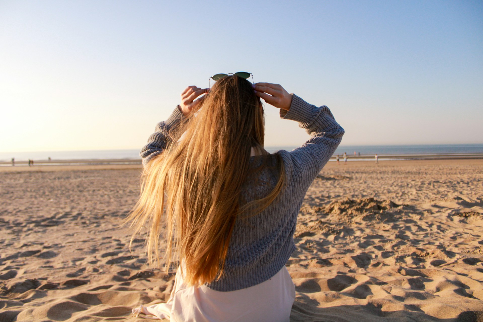 Person standing outdoors with arms crossed, illustrating the sensation of chills even in mild weather.