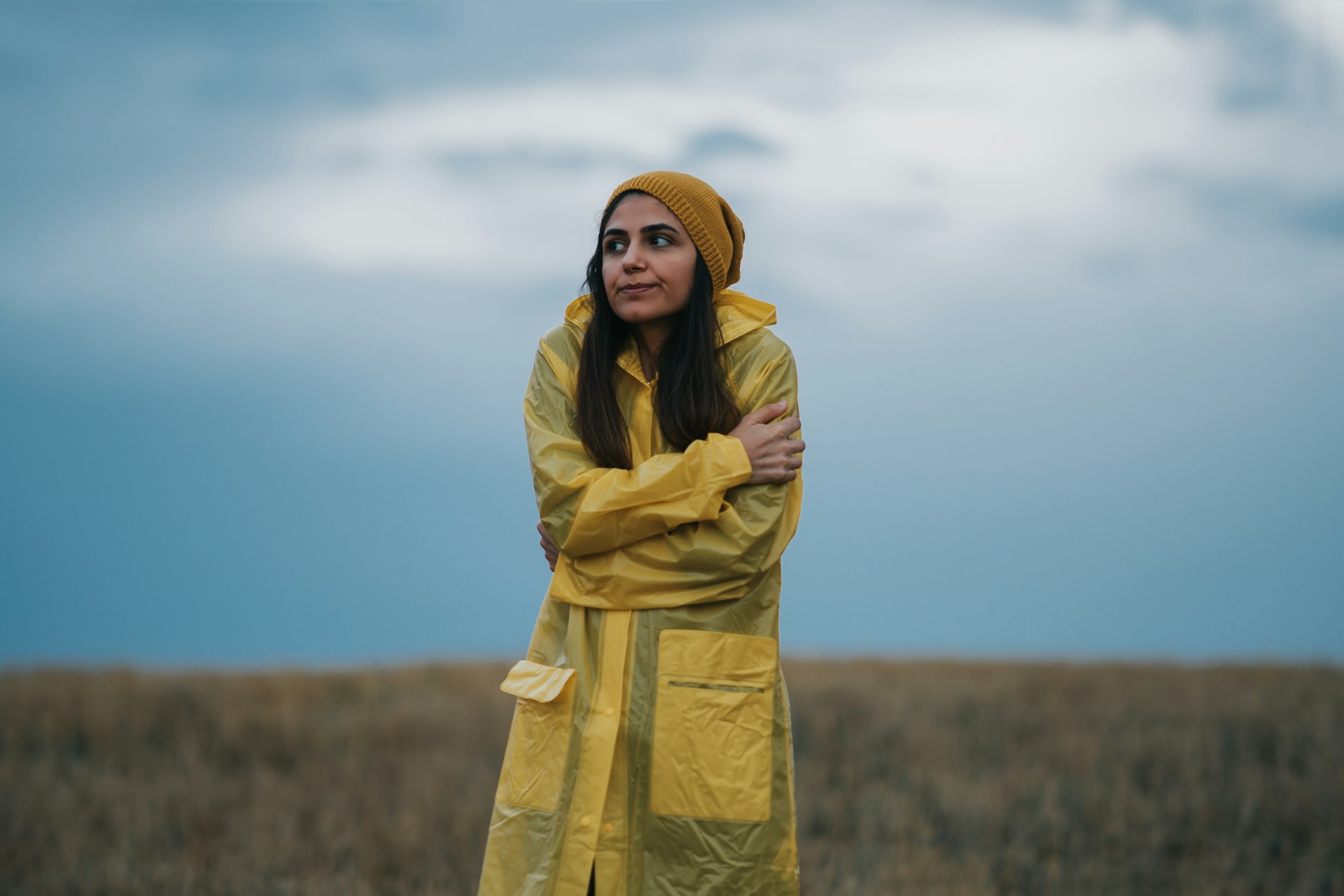 Person bundled in a yellow raincoat outdoors on a cold day.