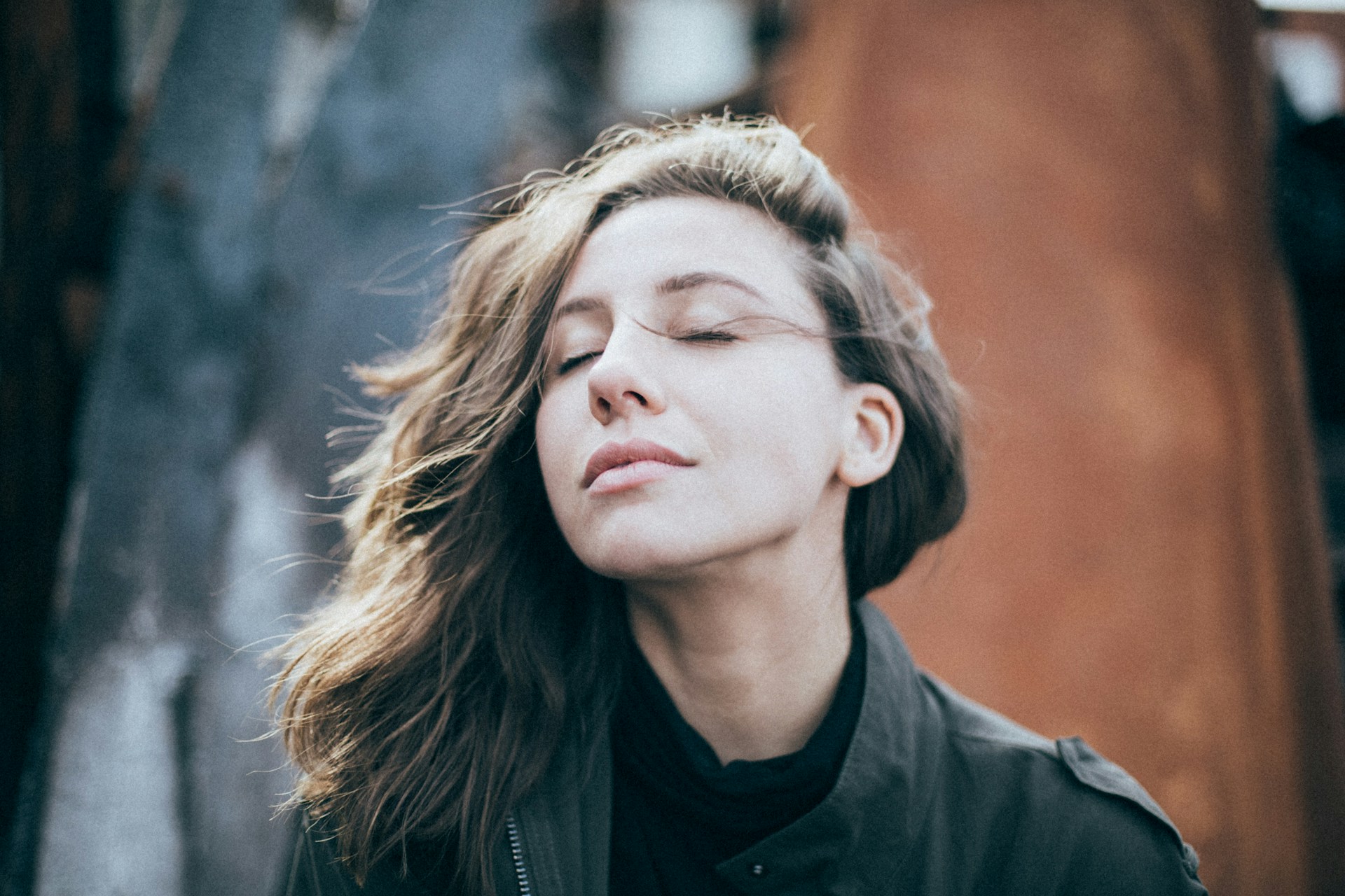 Woman taking a slow, deep breath with a calm expression.